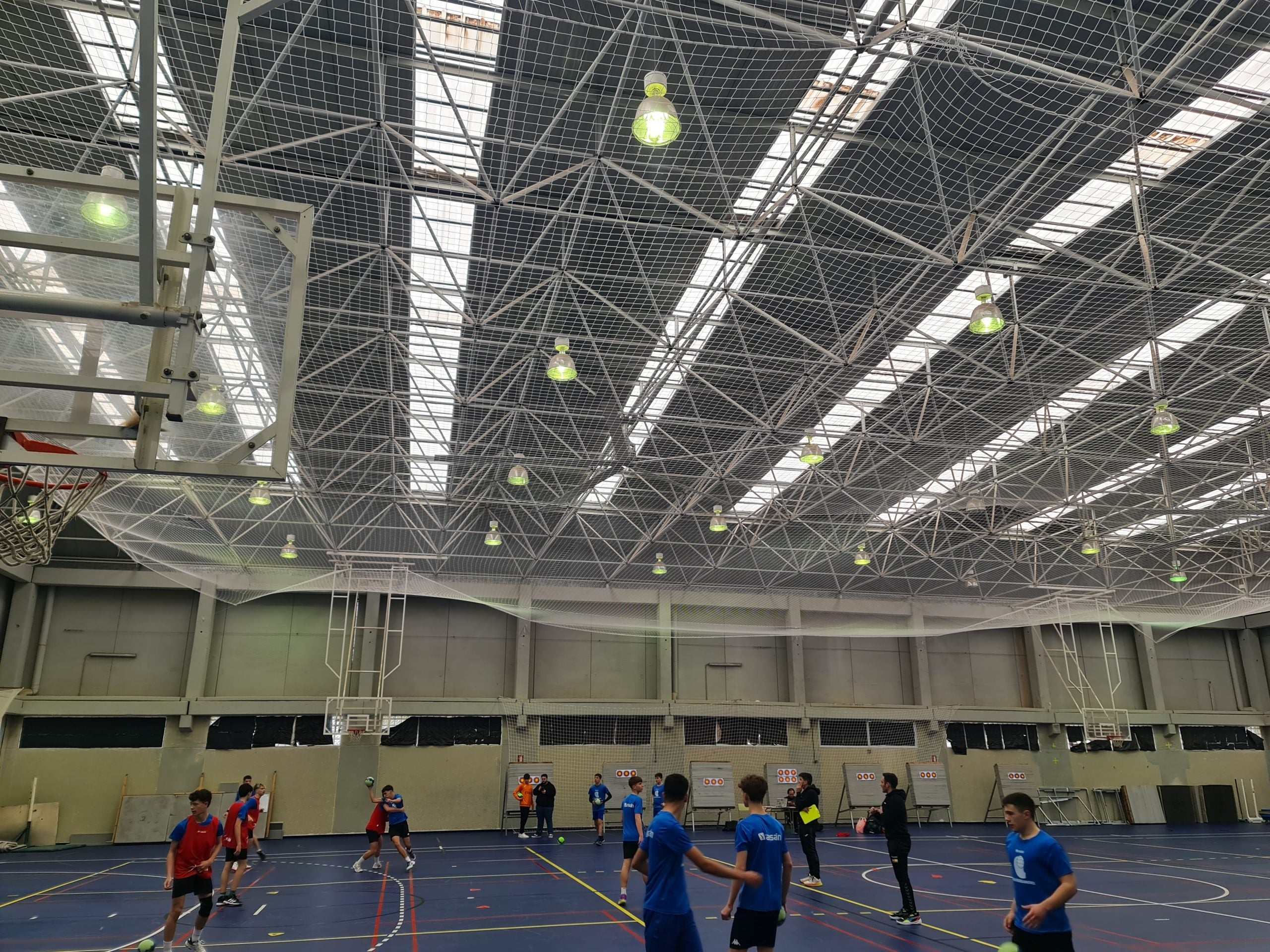 Iluminación LED en gimnasio techado con luminarias de alta calidad para espacios deportivos